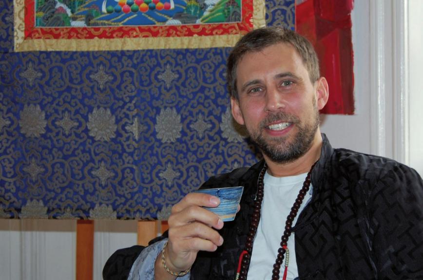 Meditationslehrer Till Ahrens auf dem elterlichen Sofa in Othmarschen vor der sogenannten Thangka FOTO: HÖSCH