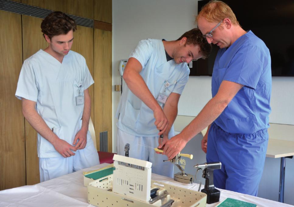 Linus Rehse und Leon Kehler lernen von Chefarzt Prof. Dr. Lars Gerhard Großterlinden, wie ein gebrochener Unterarmknochen mit einer Platte stabilisiert wird
