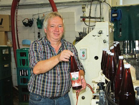Martin Schmidt füllt roten Johannisbeer-Nektar in Flaschen ab +Foto: cs Martin Schmidt füllt roten Johannisbeer-Nektar in Flaschen ab +Foto: cs