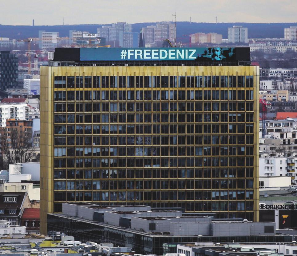 Im März und April 2017 verändert sich die sonst minütlich wechselnde Leuchtanzeige oben auf dem Springer-Hochhaus in Berlin-Kreuzberg nicht mehr: #freedeniz steht da in Großbuchstaben, während der Journalist Deniz Yücel in türkischer Haft sitzt, weil er es wagte, für seine Zeitung Die Welt vor Ort und aus erster Hand über den täglichen Demokratieabbau in der Türkei zu berichten. PICTURE ALLIANCE/AP PHOTO/MARKUS SCHREIBER