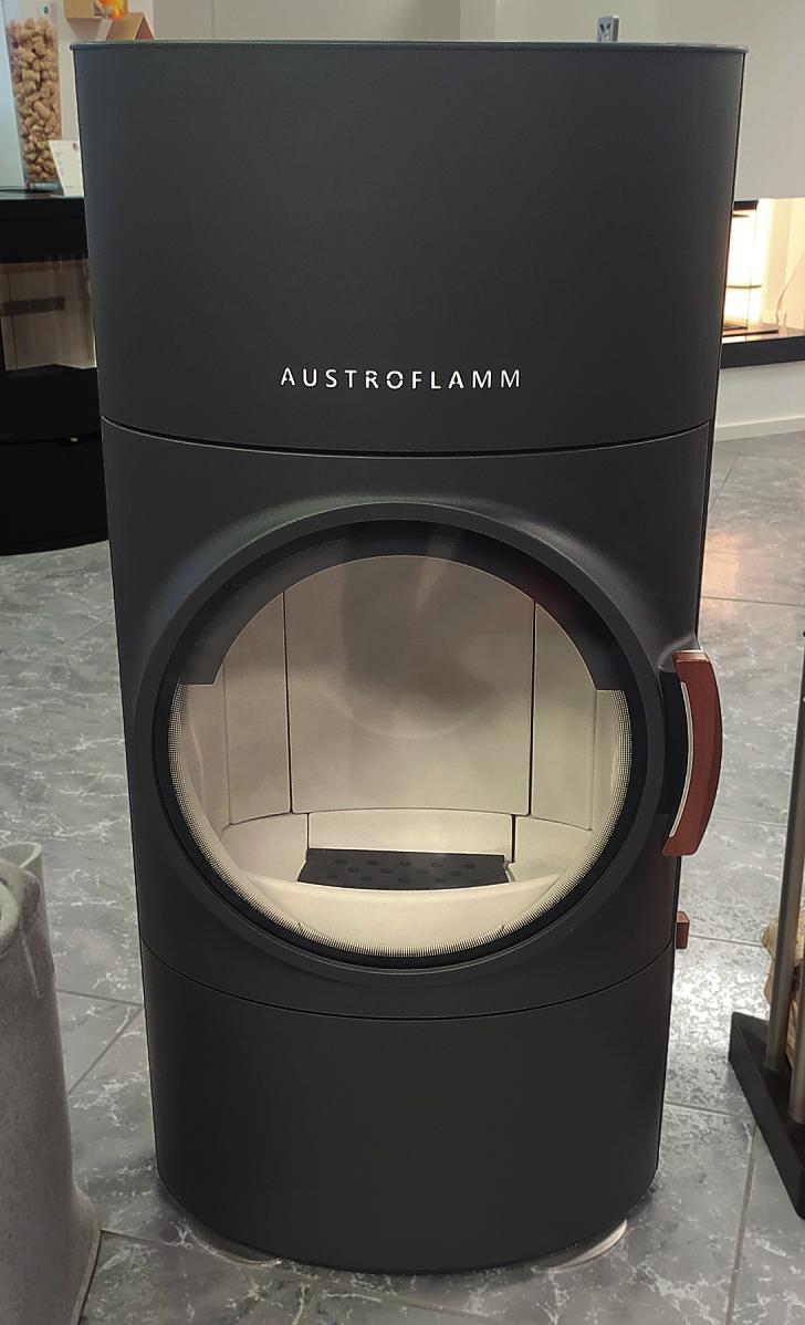 Der imposante Austroflamm Clou Xtra punktet mit einem riesigen Bullauge und einem Holzgriff aus Nussbaumholz Der imposante Austroflamm Clou Xtra punktet mit einem riesigen Bullauge und einem Holzgriff aus Nussbaumholz