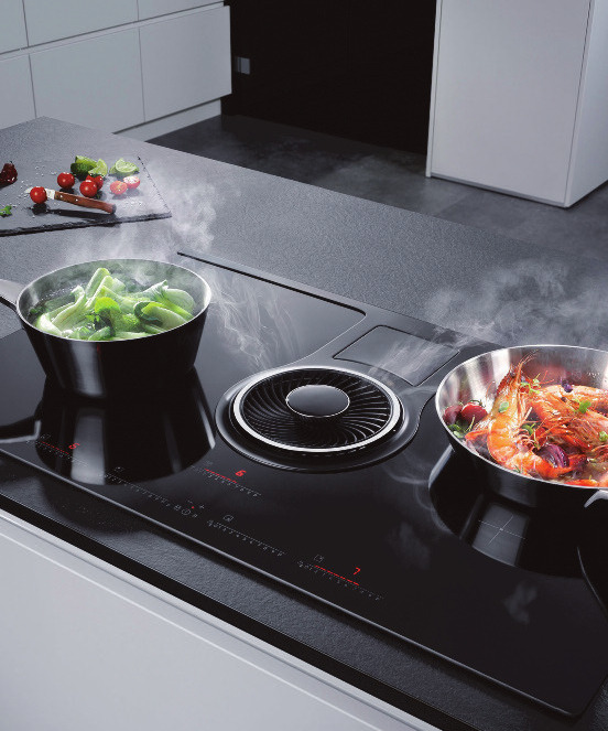 Kochen und lüften in einem: Bei dieser innovativen 2in1-Lösung ist der Dunstabzug direkt und mittig ins Induktionskochfeld integriert, sodass die kompakte Einheit in einer neuen offenen Wohnküche an jeder individuell gewünschten Position eingebaut werden kann Foto: AMK Kochen und lüften in einem: Bei dieser innovativen 2in1-Lösung ist der Dunstabzug direkt und mittig ins Induktionskochfeld integriert, sodass die kompakte Einheit in einer neuen offenen Wohnküche an jeder individuell gewünschten Position eingebaut werden kann Foto: AMK