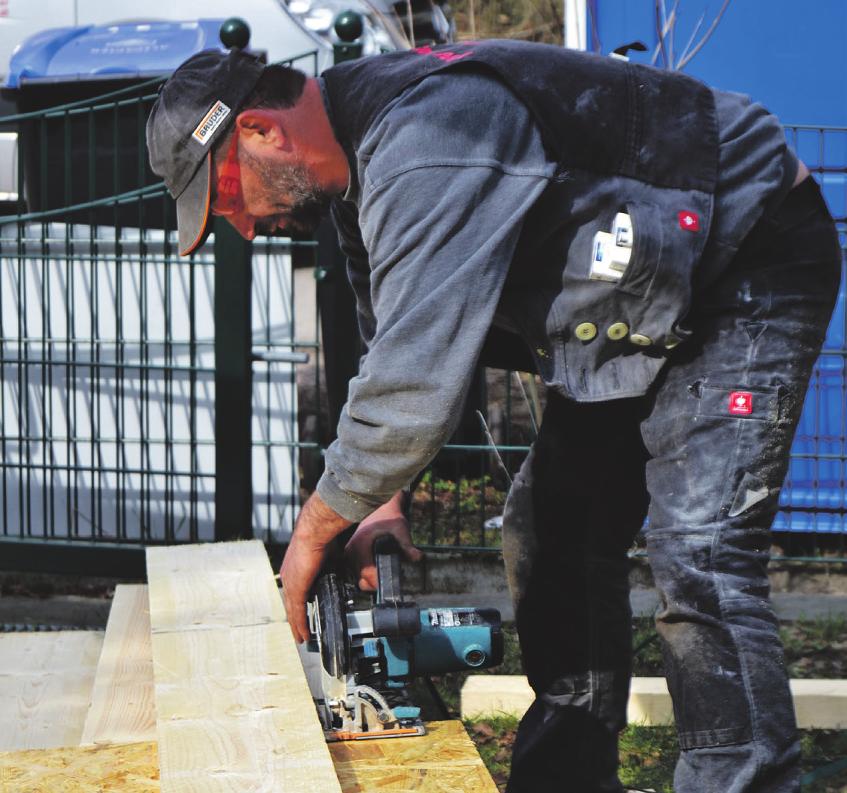 Vor Ort werden bei der Zwischensparrendämmung des Daches Holzlatten passend von Dachdecker Marco Dietz zurechtgesägt   Vor Ort werden bei der Zwischensparrendämmung des Daches Holzlatten passend von Dachdecker Marco Dietz zurechtgesägt